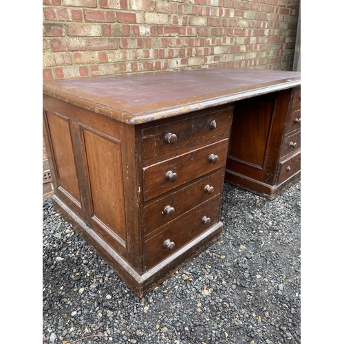 120 - A large twin pedestal mahogany station masters partners desk with a red leather top over two four dr... 