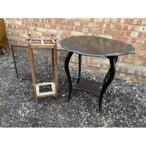 125 - A black occasional table together with a oak stickstand and a fire guard