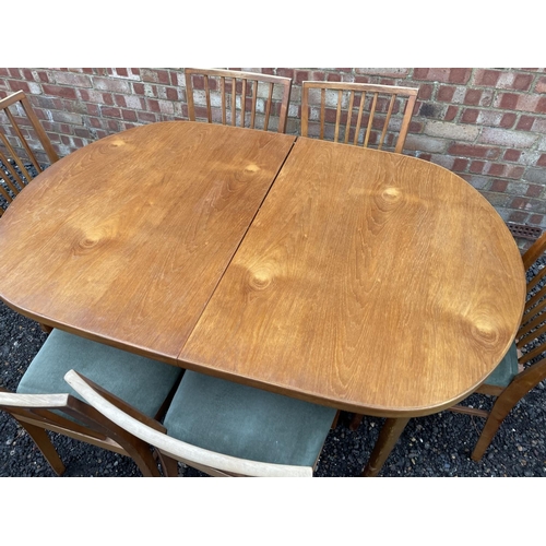 131 - A mid century extending teak dining table together with six chairs