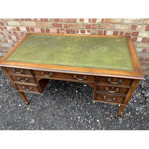 133 - A reproduction yew wood kneehole desk, fitted with 7 drawers 128x67x75