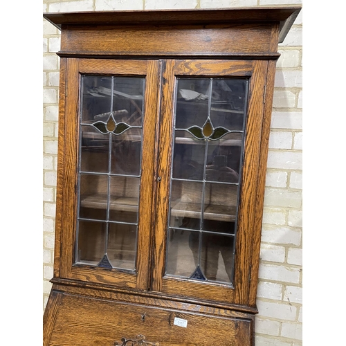 157 - A 1920's oak bureau bookcase with leaded glass top, drop down writing surface and single drawer