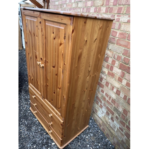 182 - A solid pine gentlemans wardrobe, hanging space over three drawer base