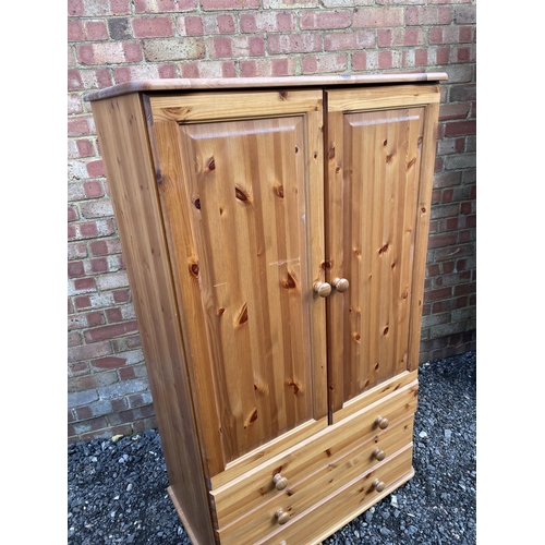 182 - A solid pine gentlemans wardrobe, hanging space over three drawer base