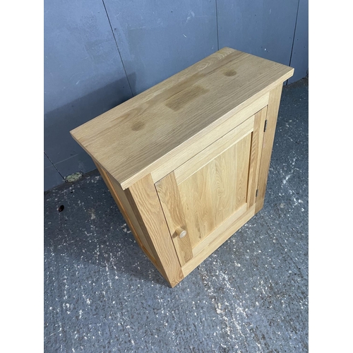 23 - A modern light oak larder cupbaord with two internal shelves 67x30x79