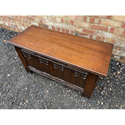 239 - A carved oak coffer with a panel front