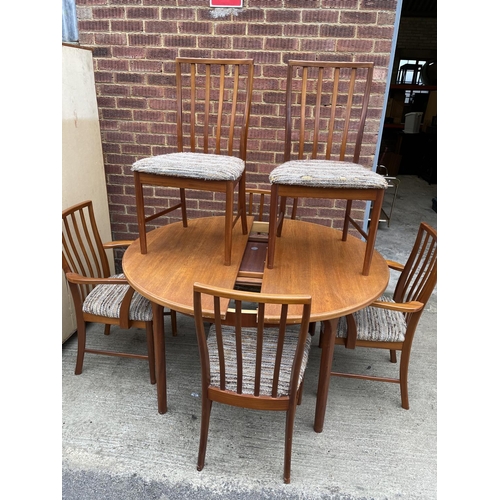 264 - A circular teak dining table by Macintosh together with a set of four six chairs