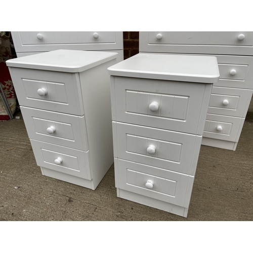 295 - A modern white four piece bedroom suite consisting of two chests and a pair of white bedsides