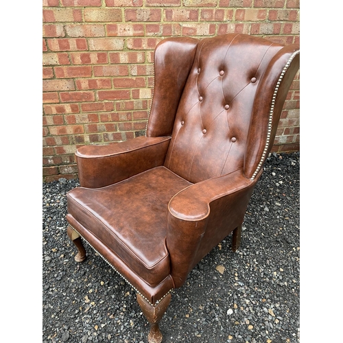 313 - A brown vinyl Chesterfield wing chair