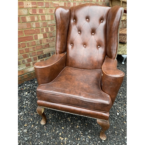 313 - A brown vinyl Chesterfield wing chair