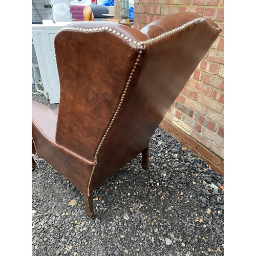 313 - A brown vinyl Chesterfield wing chair