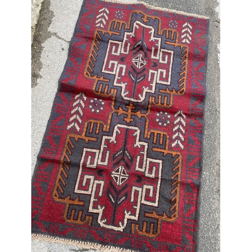 351 - A red patterned Baluchi rug 133x79