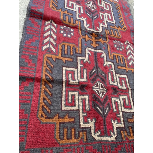 351 - A red patterned Baluchi rug 133x79