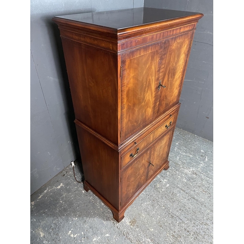 41 - A reproduction mahogany drinks cabinet, fitted with a mirror glass interior to the top, drinks slide... 