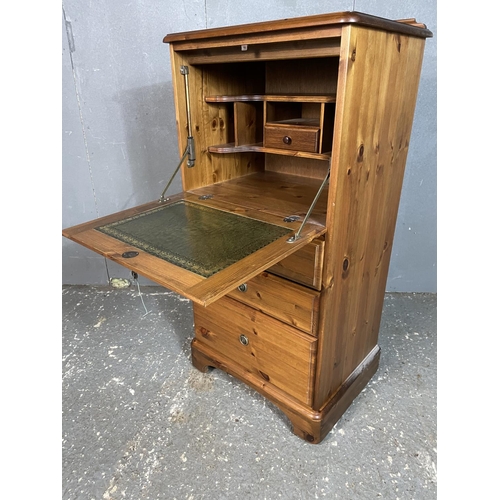 6 - A ducal pine bureau with drop down front revealing a green leather writing surface over three drawer... 