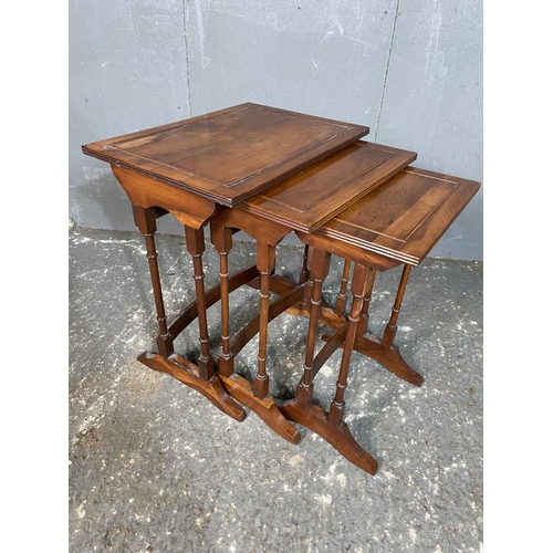 75 - A reproduction yew wood nest of tables