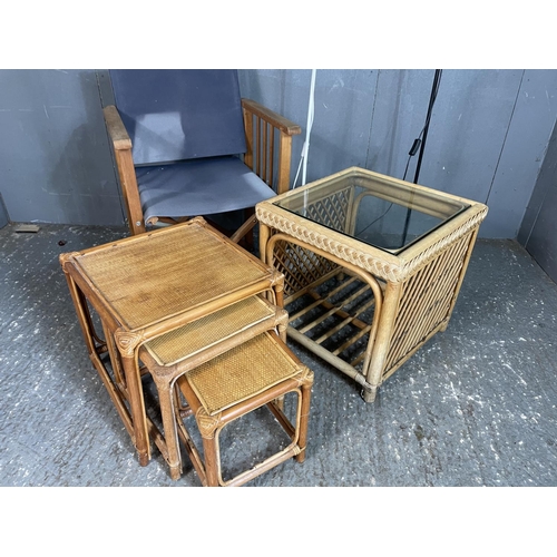 87 - A wicker nest of three, together with a bamboo ocassional table, a folding chair and two floor lamp
