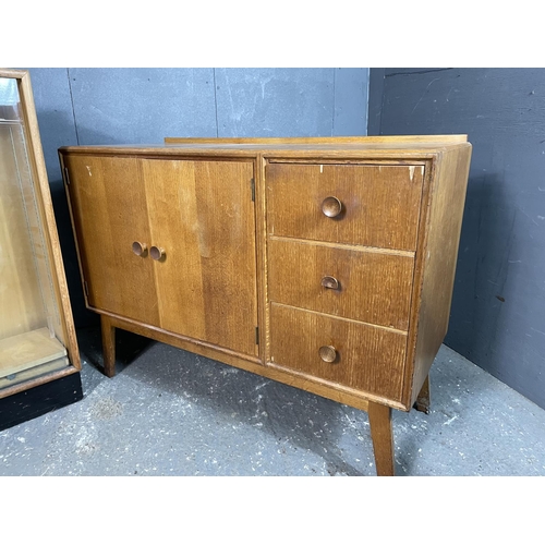 98 - A mid century light oak sideboard together with a matching glazed bookcase with two adjustable shelv... 