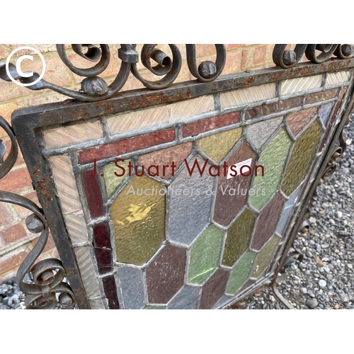 19 - A metalwork fire guard with leaded glass