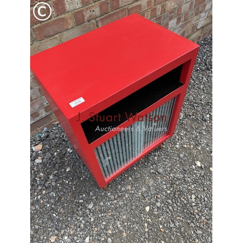 38 - A mid century red painted  record cabinet with glass sliding doors