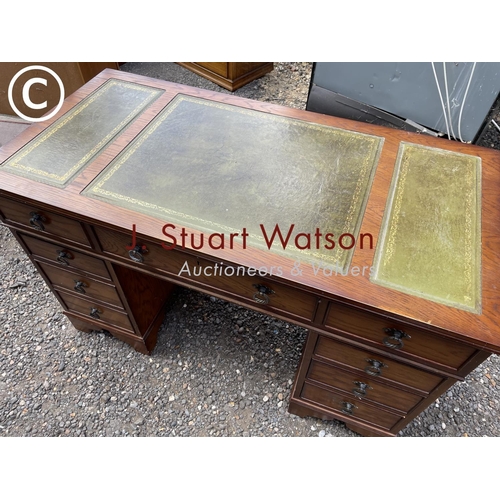 40 - An oak twin pedestal desk with a green leather top