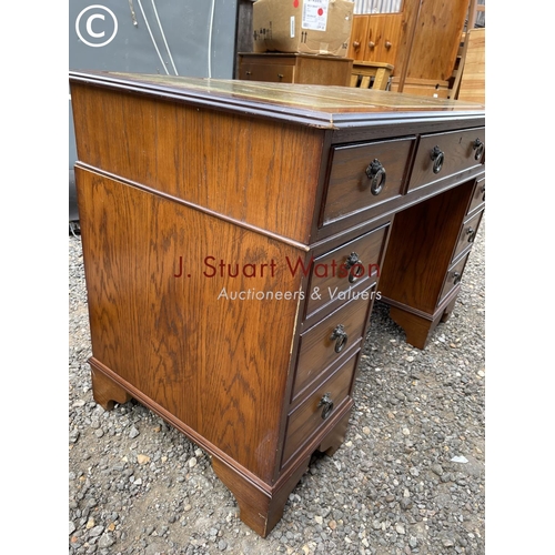 40 - An oak twin pedestal desk with a green leather top