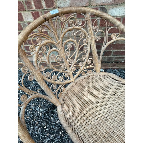 257 - A late 20th century wicker chair on metal legs with heart pattern to the back