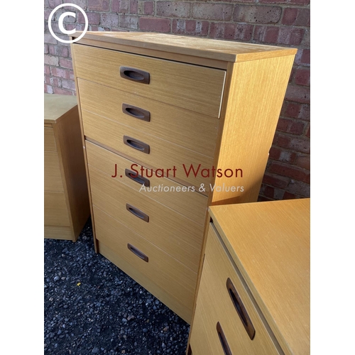 1 - A mid century teak effect tallboy chest together with a pair of three drawer bedsides