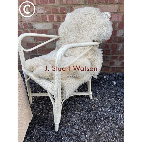 104 - A white painted wickerware chair with a wool throw together with a LLoyd loom box