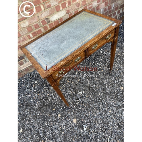 105 - A Victorian rosewood two drawer writing table with a blue leather top