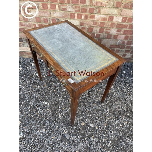 105 - A Victorian rosewood two drawer writing table with a blue leather top