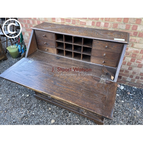 106 - A heavily carved oak bureau with fitted interior