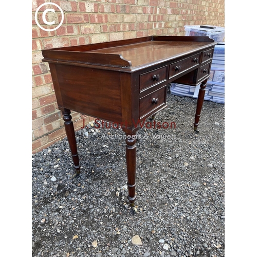 123 - A Victorian Mahogany five drawer writing table with gallery top