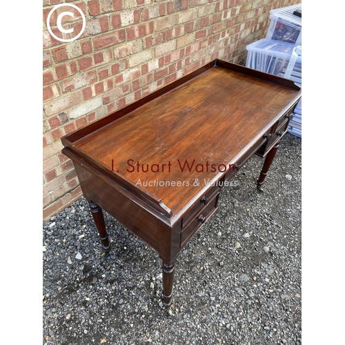 123 - A Victorian Mahogany five drawer writing table with gallery top