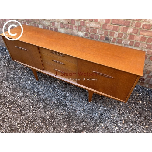 147 - a mid century teak sideboard with three central drawers flanked by cupboards