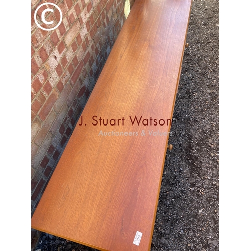 148 - a mid century teak sideboard with four central drawers flanked by cupboards