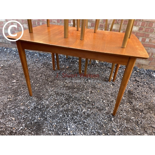 149 - A Macintosh style square extending teak dining table together with four chairs