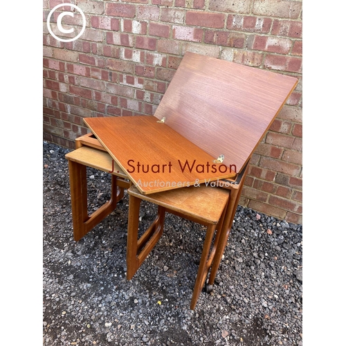 151 - A mid century teak nest of three with fold over expanding top