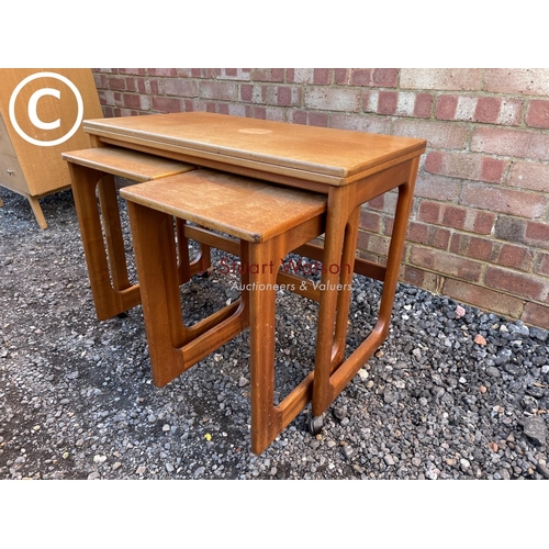 151 - A mid century teak nest of three with fold over expanding top