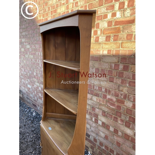 154 - An Ercol light Elm corner bookcase