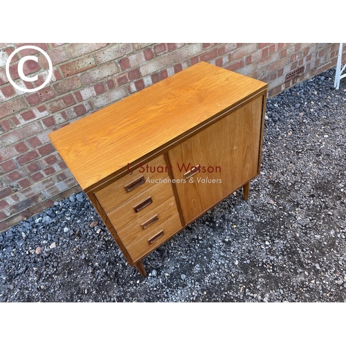 155 - A teak sewing machine cabinet