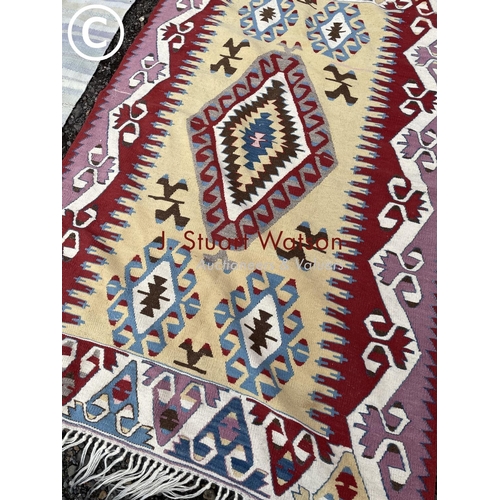 173 - A bright pattern Kilim together with a blue striped rug