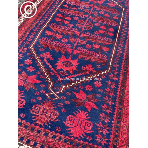 174 - A blue and red oriental pattern rug 185x115