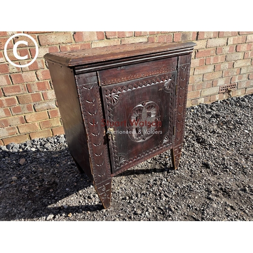 185 - A carved oak single door cupboard