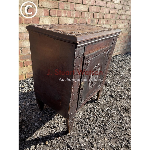 185 - A carved oak single door cupboard