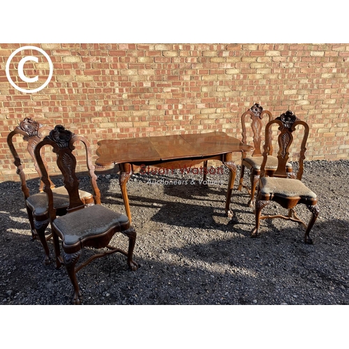 200 - An ornate mahogany ball and claw dining suite with ornate carving