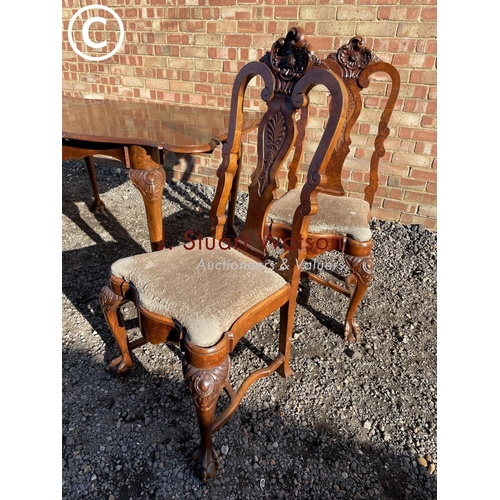 200 - An ornate mahogany ball and claw dining suite with ornate carving