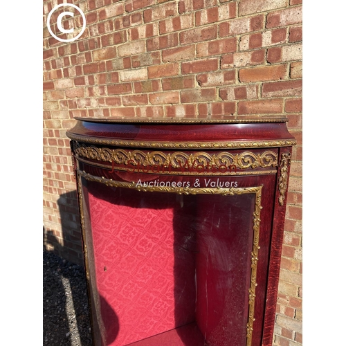 207 - A reproduction French style corner display cabinet with a bow glass front and decorated with gilt mo... 