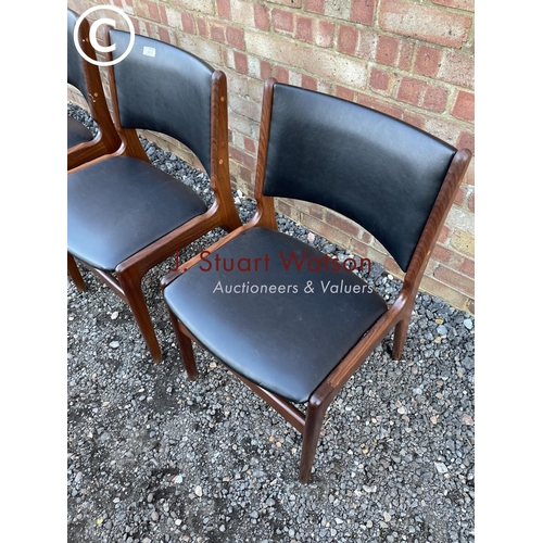 239 - A set of four Danish style teak framed dining chairs with black vinyl seats