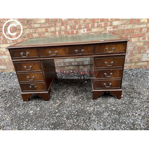 278 - A reproduction mahogany pedestal desk with a green leather top