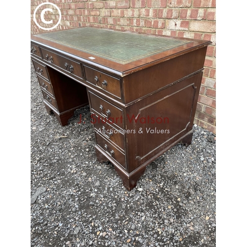 278 - A reproduction mahogany pedestal desk with a green leather top